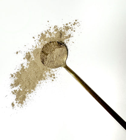 Adri Wellness's fine organic Lemongrass powder scattered on a white surface with a golden spoon