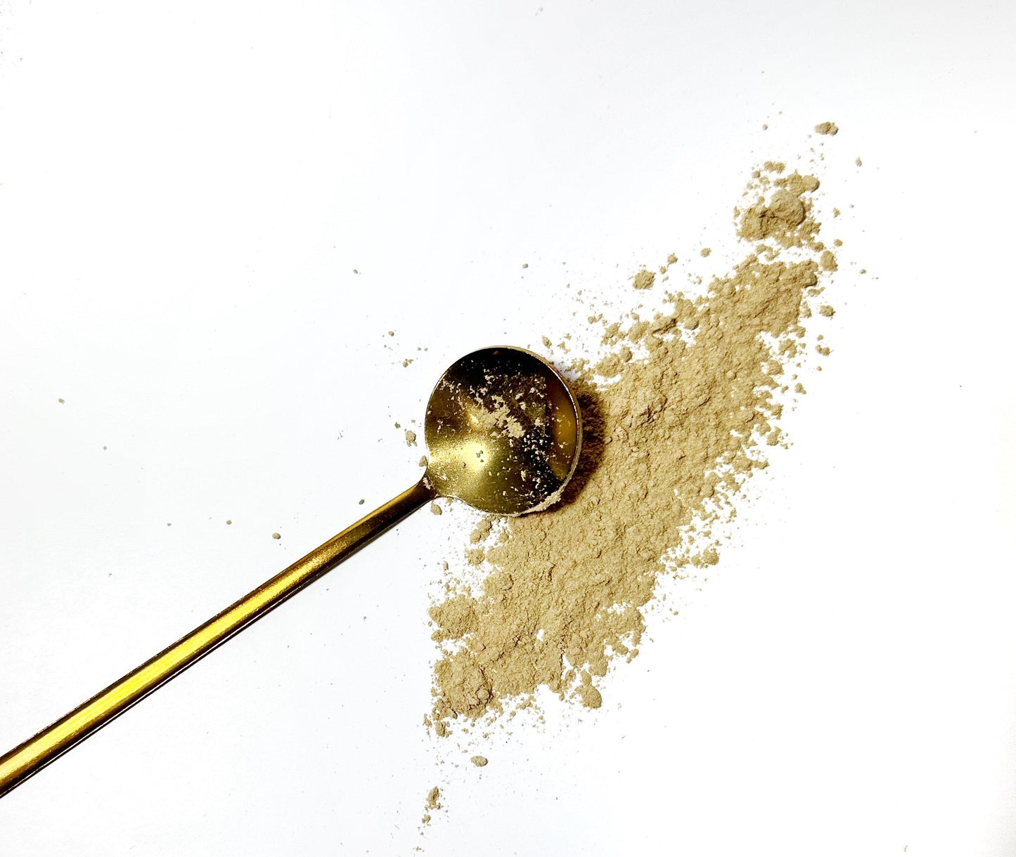 Adri Wellness's fine organic Licorice Root powder scattered on a white surface with a golden spoon