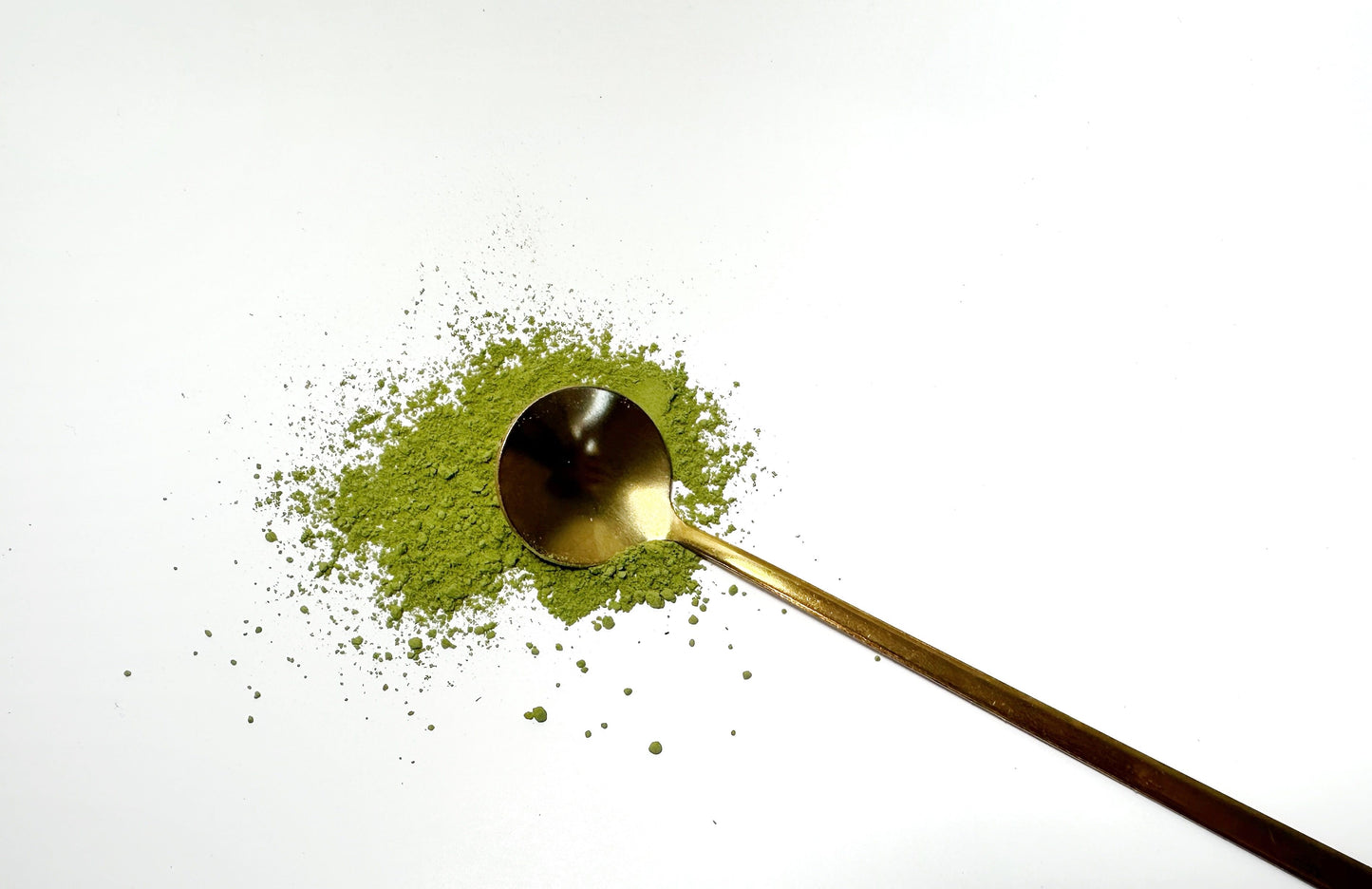 Adri Wellness's fine organic Moringa powder scattered on a white surface with a golden spoon