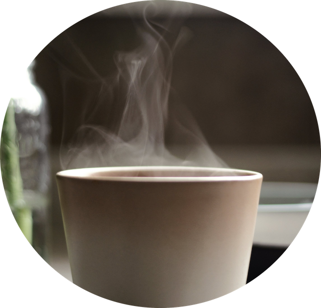 a cup of warm beverage with steam coming out of it 