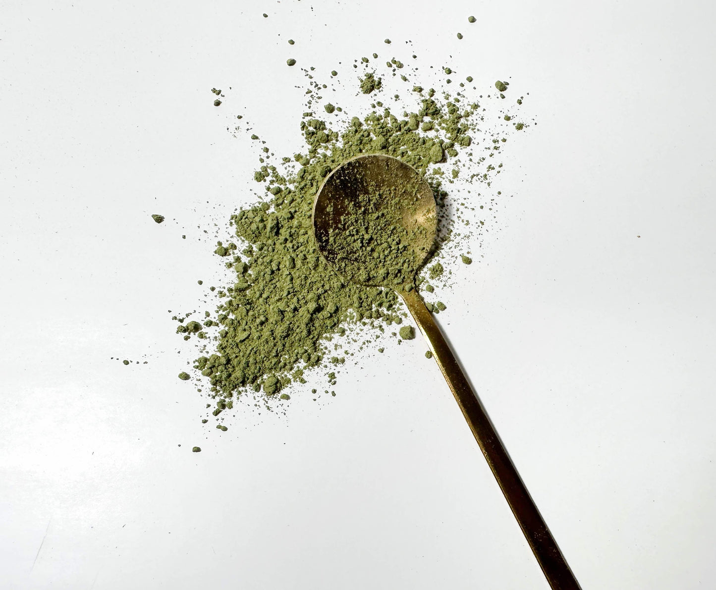 Adri Wellness's fine organic Stevia Leaves powder scattered on a white surface with a golden spoon