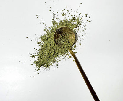 Adri Wellness's fine organic Stevia Leaves powder scattered on a white surface with a golden spoon