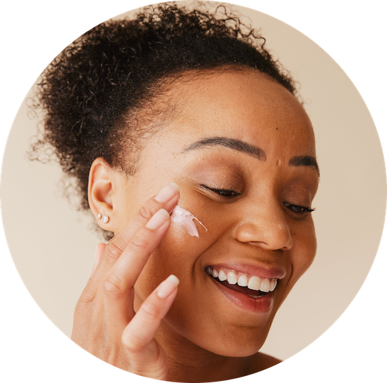 Girl applying skincare treatment on her face with a smile